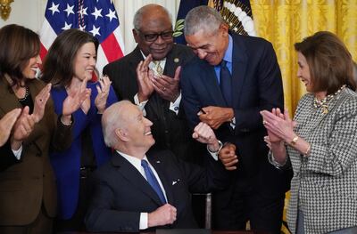 US President Joe Biden bumps fists with former president Barack Obama in the White House on April 5, alongside Vice President Kamala Harris, House Speaker Nancy Pelosi, and US representatives. AFP