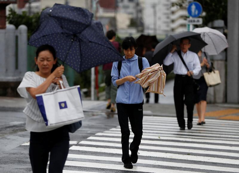 Passersby using umbrellas struggle against heavy rain and wind wind caused by Typhoon Faxai in Tokyo, Japan September 9, 2019. REUTERS/Issei Kato