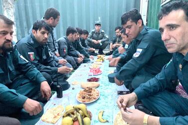 Afghan policemen gather for their iftar in a bunkered enclosure at a check-post in central Kabul. They take turns to break their fast while their colleagues stand guard outside. Hikmat Noori for The National