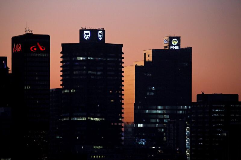 FILE PHOTO: The buildings with the logos of three of South Africa's biggest banks, ABSA, Standard Bank and First National Bank (FNB), are seen against the city skyline in  Cape Town, South Africa, September 3, 2017. Picture taken September 3, 2017. REUTERS/Mike Hutchings/File Photo