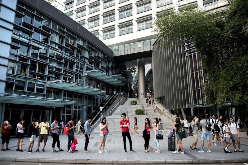 Students line up for a bus service at the Chinese University of Hong Kong, in Hong Kong on September 4, 2014. A group of Hong Kong students on September 4 proposed plans to hold a week-long strike later in the month in response to Beijing's refusal to grant the semi-autonomous city full universal suffrage. AFP PHOTO / ALEX OGLE (Photo by Alex Ogle / AFP)