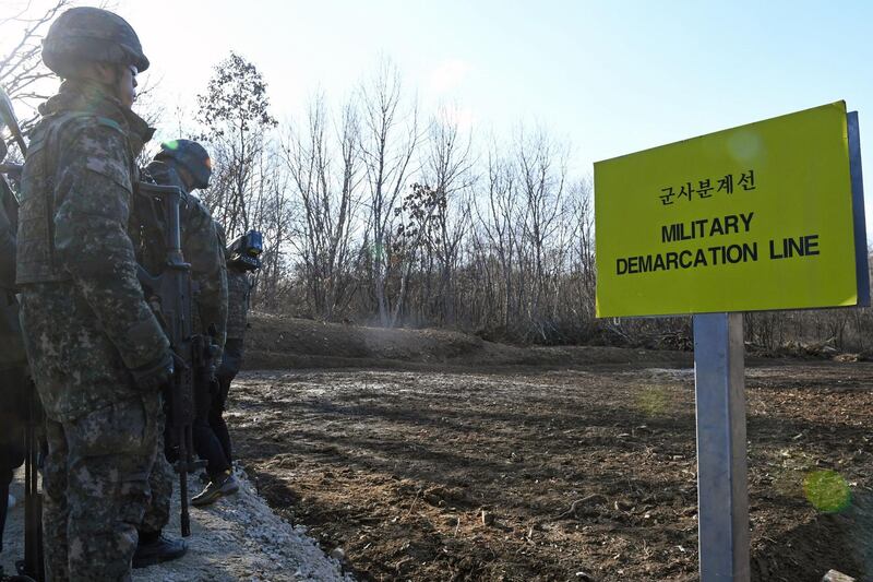 South Korean soldiers stand at Arrowhead Ridge, a site of battles in the 1950-53 Korean War, as a tactical road is built across the military demarcation line inside the Demilitarized Zone (DMZ) in the central section of the inter-Korean border in Cheorwon, Gangwon Province, in South Korea on November 22, 2018. North and South Korea have connected a road across their shared border for the first time in 14 years, Seoul's defence ministry said on November 22 in the latest reconciliation gesture between the neighbours. / AFP / POOL / Kim Min-Hee
