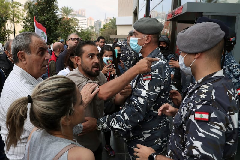 Bank customers scuffle with riot police as they try to storm a bank in Beirut, Lebanon. AP