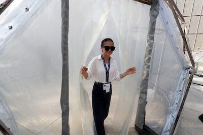 Clean Air Fund's Regina Zhyldyzbekova comes out of one of the pollution pods at Expo City Dubai.  Pawan Singh / The National