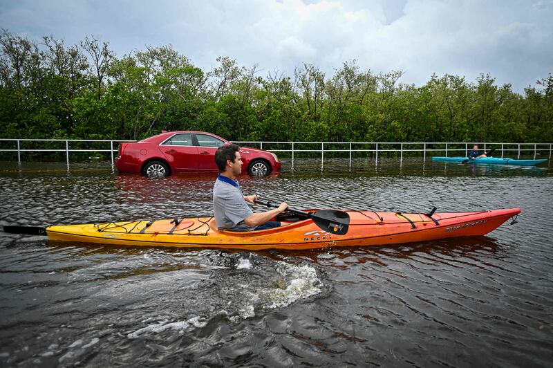 Residents use kayaks to travel on a flooded road in Tampa. AFP