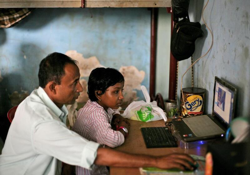 Senwara Begum, right, is helped by her foster father, hamsul bin Sayed,to use Skype to talk to her family members in Myanmar from their temporary shelter in Medan, North Sumatra, Indonesia. "I'm fine," Senwara says, trying to sound upbeat. "I'm with a family that is taking good care of me. They love me. I'm learning things, English and religion." Her father reminds her to be a good girl. He is desperate to see his children again, but believes they are better off far away. AP Photo/Binsar Bakkara