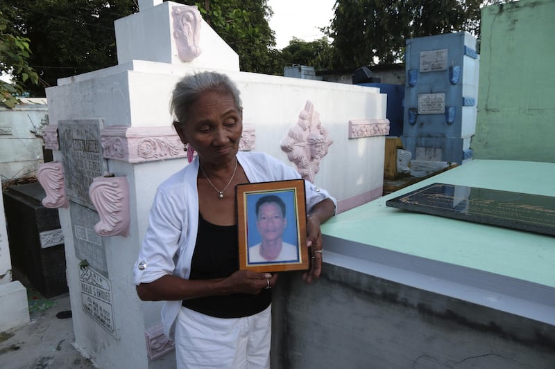 Elvira Miranda holds up a picture of her son Leover, who was killed by the anti-drugs police in the Manila cemetery where he lived. Mrs Miranda denies that her son was involved in drugs. Florian Neuhof  for The National