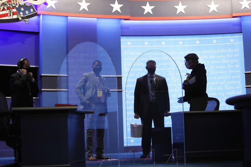 Staff members prepare the debate stage behind plexiglass shields. Bloomberg