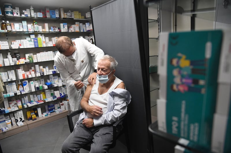 A pharmacist administers a third dose of Pfizer-BioNTech's coronavirus vaccine in Milan, Italy, on Wednesday. EPA