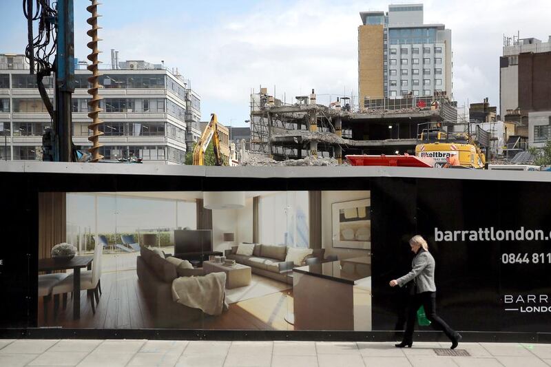 A woman walks past a sign advertising new luxury apartments in London’s East End.tThe Organisation for Economic Co-operation and Development said that Britain should take action over soaring house prices, perhaps by scaling back the government’s mortgage guarantee scheme. Dan Kitwood / Getty Images
