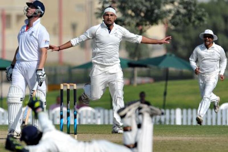 ICC Combined XI cricketer Hamid Hassan (C) celebrates with his teammates after he dismissed England XI cricketer Jonathan Trott (L) during the second day of a three-day practice match between the England XI and ICC Combined XI at The ICC Global Cricket Academy in Dubai Sports City on January 8, 2012. England plays three Tests, four one-day internationals and three Twenty20s against Pakistan in the United Arab Emirates between January 17 and February 27.     AFP PHOTO/Lakruwan WANNIARACHCHI


