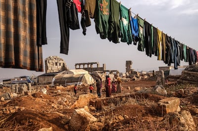 A displaced Syrian family wait for aid near their tent, next to the Roman ruins near Kefer Losing camp on the outskirts of Idlib, Syria, on November 25, 2021. EDA