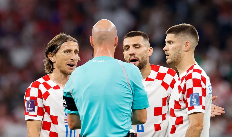 From left, Croatian players Luka Modric, Mateo Kovacic, and Andrej Kramaric argue with referee Anthony Taylor. EPA