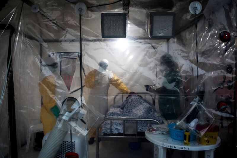 Three medical workers check on an Ebola patient in a Biosecure Emergency care Unite (CUBE) on August 15, 2018 in Beni. AFP