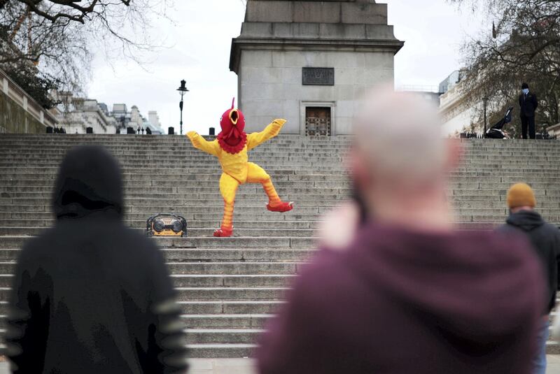A person dressed in a chicken costume dances to music on Good Friday in London, Britain, April 2, 2021. REUTERS/Hannah McKay