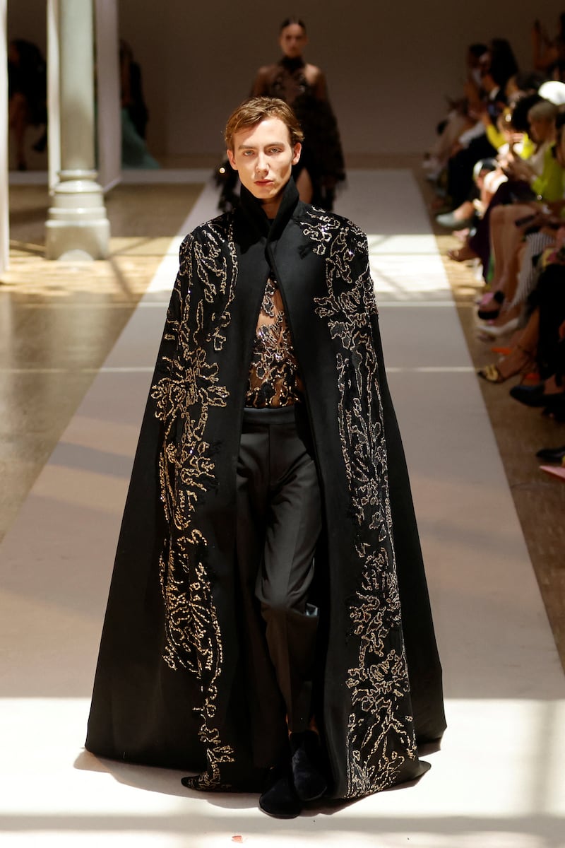 A male model wears an embroidered cape. Reuters