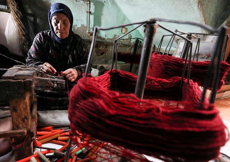 A close up shows Madiha Alkhouly weaving in the textile workshop in the village of Atmida, in Dakahliya governorate, Egypt. Reuters