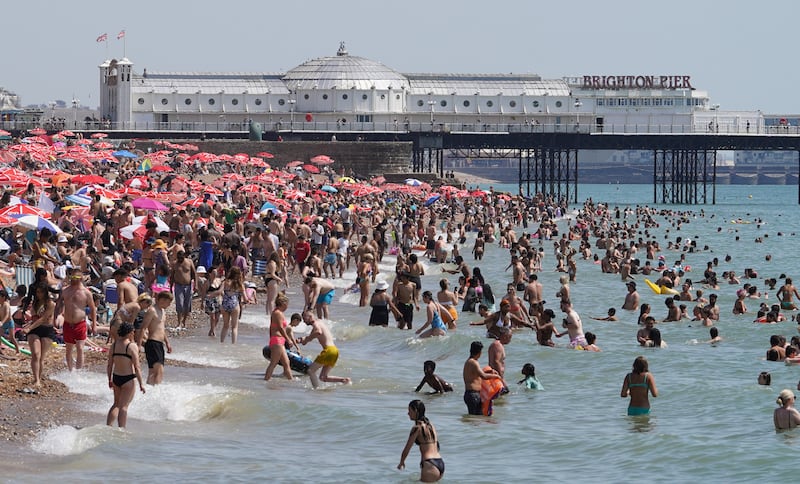 People basking in the sun on a crowded Brighton beach. The temperature in Britain smashed through the 40ºC barrier for the first time in recorded history. PA