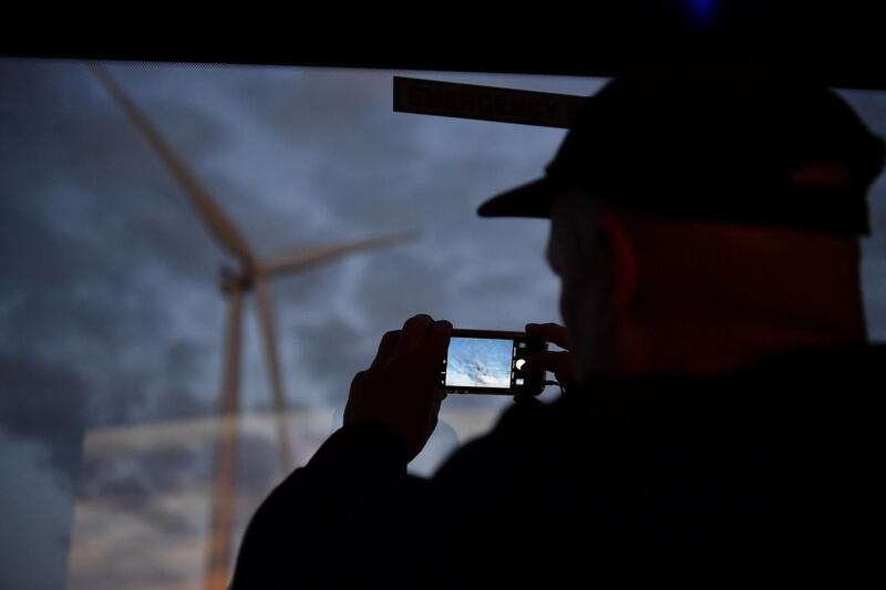 A silhouette of a man taking a photo of a wind turbine is seen at the TESLA battery plant outside of Jamestown, South Australia, September 29, 2017. Picture taken September 29, 2017. AAP/Morgan Sette/via REUTERS ATTENTION EDITORS - THIS IMAGE WAS PROVIDED BY A THIRD PARTY. NO RESALES. NO ARCHIVE. AUSTRALIA OUT. NEW ZEALAND OUT.?