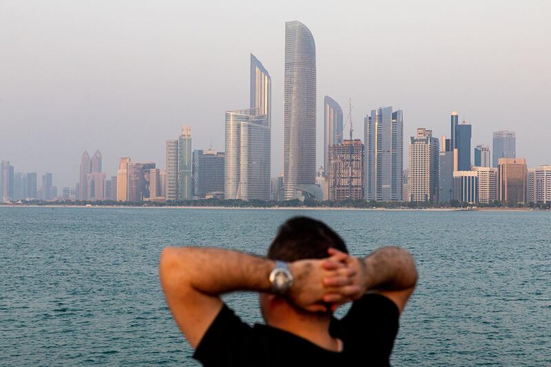 A visitor looks at the view of the city skyline from a breakwater in Abu Dhabi, United Arab Emirates, on Wednesday, Oct. 2, 2019. Abu Dhabi sold $10 billion of bonds in a three-part deal in its first international offering in two years as it takes advantage of relatively low borrowing costs. Photographer: Christopher Pike/Bloomberg