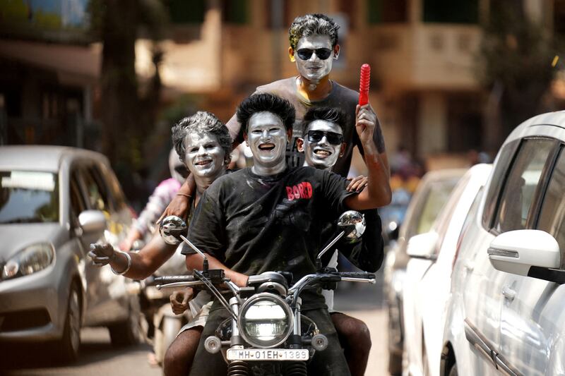 Boys with their faces painted in silver ride a motorbike during Holi celebrations in Mumbai, India. Reuters