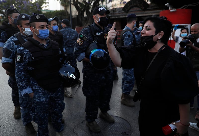 An anti-government protester shouts slogans in font of riot policemen during a protest in Beirut, Lebanon. AP Photo