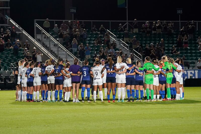 North Carolina Courage and Racing Louisville FC players pause and gather at midfield during the first half of an NWSL soccer match in Cary, N. C. AP Photo