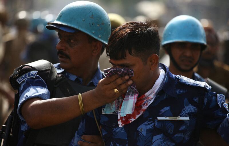 An injured policeman receives help during a protest in Prayagraj. Reuters