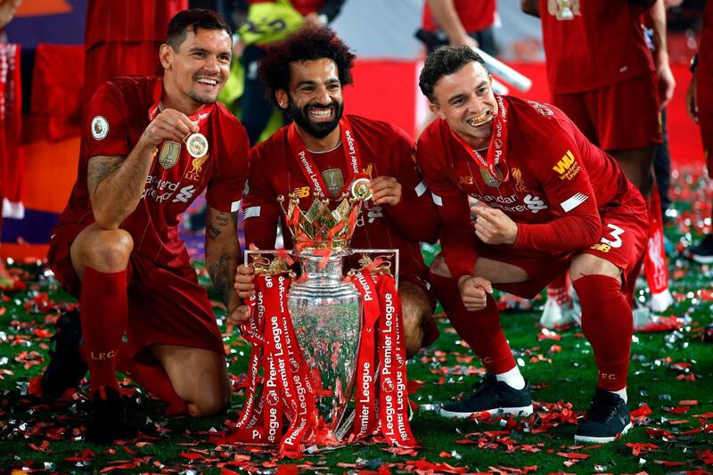 Liverpool's Croatian defender Dejan Lovren (L), Liverpool's Egyptian midfielder Mohamed Salah (C) and Liverpool's Swiss midfielder Xherdan Shaqiri (R) pose with the Premier League trophy during the presentation following the English Premier League football match between Liverpool and Chelsea at Anfield in Liverpool, north west England on July 22, 2020. Liverpool on Wednesday lifted the Premier League trophy at the famous Kop stand at Anfield after their final home game of the season. With no fans able to attend due to the COVID-19 coronavirus pandemic, Liverpool said the idea for the trophy lift was to honour the club's fans, but Liverpool manager Jurgen Klopp urged fans to respect social distancing measures, after thousands gathered around the club's stadium and in the city centre following their coronation as champions last month. - RESTRICTED TO EDITORIAL USE. No use with unauthorized audio, video, data, fixture lists, club/league logos or 'live' services. Online in-match use limited to 120 images. An additional 40 images may be used in extra time. No video emulation. Social media in-match use limited to 120 images. An additional 40 images may be used in extra time. No use in betting publications, games or single club/league/player publications.
 / AFP / POOL / PHIL NOBLE / RESTRICTED TO EDITORIAL USE. No use with unauthorized audio, video, data, fixture lists, club/league logos or 'live' services. Online in-match use limited to 120 images. An additional 40 images may be used in extra time. No video emulation. Social media in-match use limited to 120 images. An additional 40 images may be used in extra time. No use in betting publications, games or single club/league/player publications.
