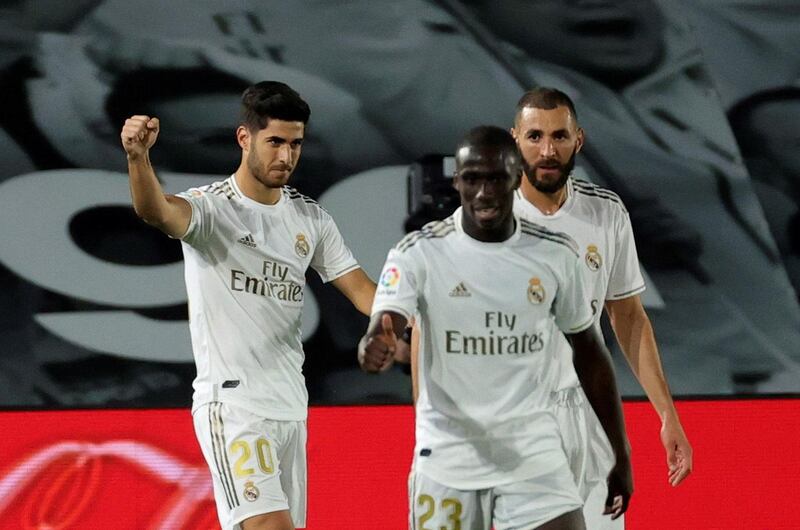 Real Madrid's Marco Asensio, left, celebrates with Karim Benzema and Ferland Mendy after scoring against Valencia. EPA