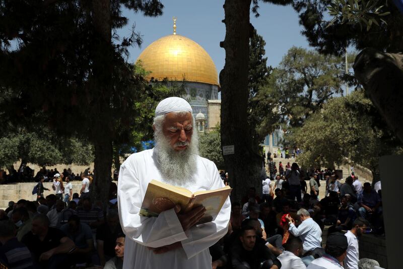 A worshipper reads as he takes part in Friday prayers at the Dome of the Rock shrine in the Al Aqsa Mosque compound, in the Old City of Jerusalem. AP Photo