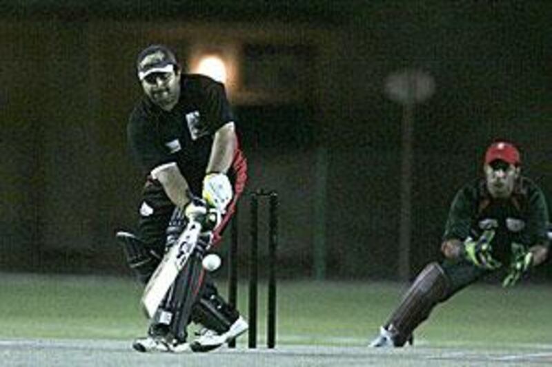 Altaf Mohammed of UAE bats as Niyaz Ahmed of Oman looks on.