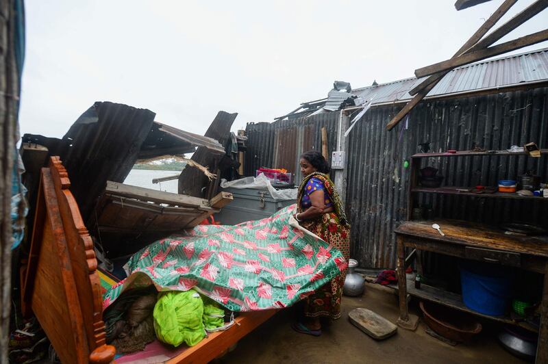 A woman salvages items from her house damaged by cyclone Amphan in Satkhira. AFP
