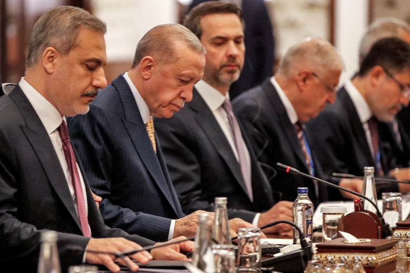 Mr Erdogan, second left, and Turkey's Foreign Minister Hakan Fidan, left, follow proceedings. Reuters