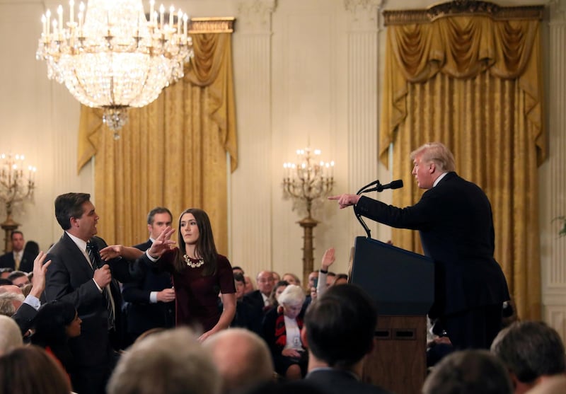A White House staff member reaches for the microphone held by CNN's Jim Acosta as he questions US President Donald Trump during a news conference following the midterm US congressional elections at the White House on November 7, 2018. Reuters