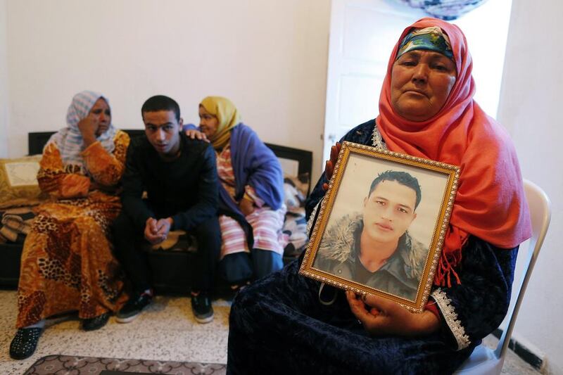 Nour Al Houda (R), 65, poses with a portrait of her son Anis Amri at her home in Oueslatia, Tunisia, on December 22, 2016. Mohamed Messra/EPA  