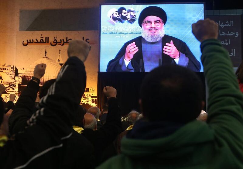 Supporters raise their hands and shout slogans as Hizbollah's leader Sheikh Hassan Nasrallah addresses them via a video link in the southern suburbs of Beirut, Lebanon on February 16, 2015. Hussein Malla/AP Photo