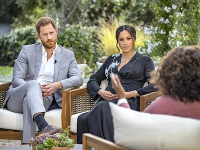 FILE - This image provided by Harpo Productions shows Prince Harry, from left, and Meghan, Duchess of Sussex, in conversation with Oprah Winfrey. Almost as soon as the interview aired, many were quick to deny Meghan‚Äôs allegations of racism on social media. Many say it was painful to watch Meghan's experiences with racism invalidated by the royal family, members of the media and the public, offering up yet another example of a Black woman's experience being disregarded and denied. (Joe Pugliese/Harpo Productions via AP, File)