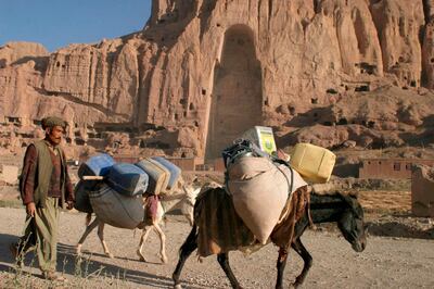 epa09044158 (FILE) An Afghan Hazara man with his donkeys walks by the Buddha caves on Sunday, 14 August 2005 in Bamiyan,  Afghanistan 14 August 2005 (reissued 01 March 2021). The monumental Buddha statues of Bamyan were, until their destruction, one of the best-known historic and cultural sights of Afghanistan. Carved from the cliff in the early 6th and 7th centuries AD they date to an era when Buddhism was the dominant religion in the region, and when Bamyan was an important center on the network of trade routes between China, Europe, India, and central Asia. The eastern Buddha (38m high) was carved first, in the middle of the 6th century, and the western Buddha (55m) in the early 7th century. The hundreds of nearby caves were used by monks and were once decorated with elaborate wall paintings.    EPA/SYED JAN SABAWOON