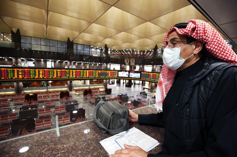A Kuwaiti trader wearing a protective mask follows the market at the Boursa Kuwait stock exchange in Kuwait City on March 1, 2020. Boursa Kuwait decided to close the main trading hall due to the COVID-19 coronavirus disease developments. Stock markets in the oil-rich Gulf states plunged on March 1 over fears of the impact of the coronavirus, which also battered global bourses last week. All of the seven exchanges in the Gulf Cooperation Council (GCC), which were closed the previous two days for the Muslim weekend, were hit as oil prices dropped below $50 a barrel. The region's slide was led by Kuwait Boursa, where the All-Share Index fell 10 percent, triggering its closure. Kuwait's bourse was closed for most of last week for national holidays. / AFP / YASSER AL-ZAYYAT
