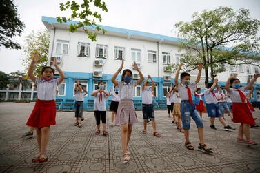 Children wear face masks for gymnastic exercises at an elementary school in Hanoi, Vietnam, after returning from three months off. EPA
