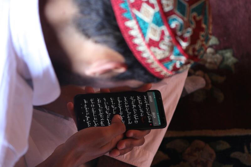 A Kashmiri Muslim boy recites the Quran from the mobile phone on the first day of fasting month of Ramadan inside Jamia Masjid (Kashmir's Grand Mosque) in Srinagar,the summer capital of Indian Kashmi.  EPA
