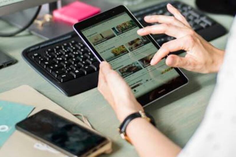 In this Tuesday, May 21, 2019 photo, Franziska Lienert spokeswoman of the company which runs the food sharing app 'Too Good To Go', uses a tablet to find a restaurant participating with the food sharing community, during an interview with the Associated Press in Berlin. In Germany, growing numbers of people use modern technology such as phone apps to help reduce food waste. In an effort to cut down on climate-wrecking carbon dioxide emissions created by food waste, they build online communities to share food before throwing it away. (AP Photo/Markus Schreiber)