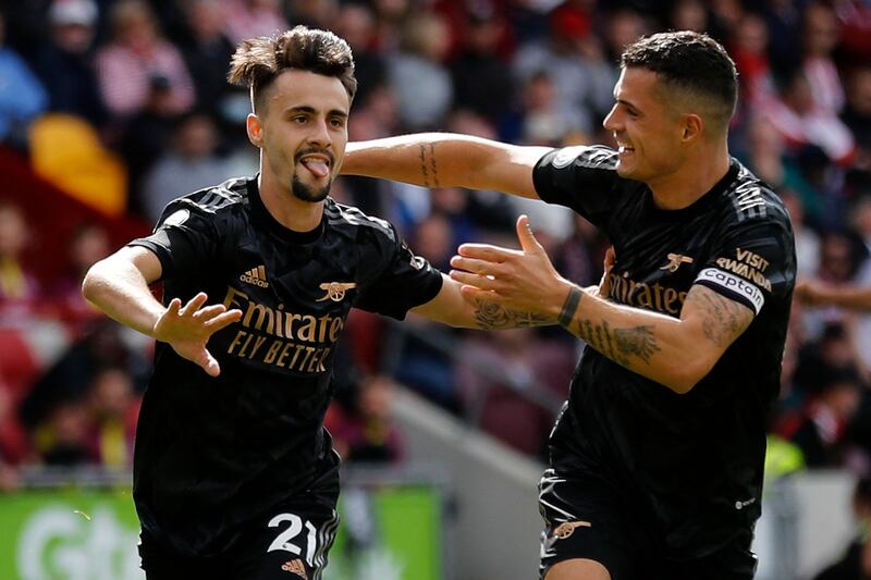 Arsenal's Portuguese midfielder Fabio Vieira (L) celebrates with Arsenal's Swiss midfielder Granit Xhaka after scoring the team's third goal during the English Premier League football match between Brentford and Arsenal at the Gtech Community Stadium in London on September 18, 2022.  (Photo by Ian Kington / AFP) / RESTRICTED TO EDITORIAL USE.  No use with unauthorized audio, video, data, fixture lists, club/league logos or 'live' services.  Online in-match use limited to 120 images.  An additional 40 images may be used in extra time.  No video emulation.  Social media in-match use limited to 120 images.  An additional 40 images may be used in extra time.  No use in betting publications, games or single club/league/player publications.   /  