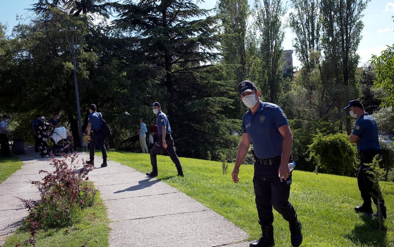 Police officers wearing face masks to protect against the spread of coronavirus, patrol in a public garden, warning people to respect social distancing, in Ankara. AP Photo