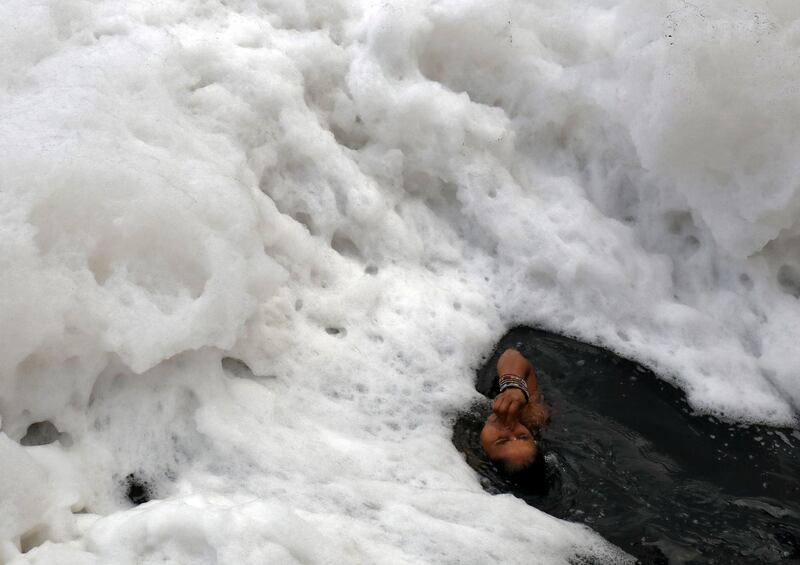 A woman takes a dip in the polluted waters of the river Yamuna in New Delhi. Reuters