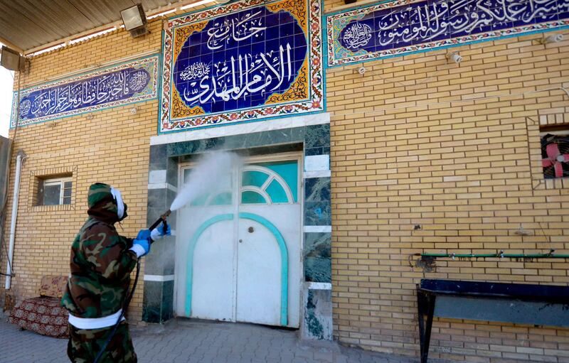A member of the Iraqi civil defence disinfects the entrance of a mosque in the central shrine city of Najaf. AFP