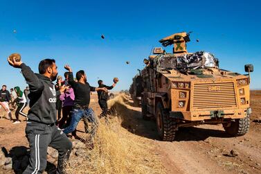 Kurdish demonstrators hurl rocks at a Turkish military vehicle on November 8, 2019, during a joint Turkish-Russian patrol near the town of Al Muabbadah in the north-east Hassakah. AFP