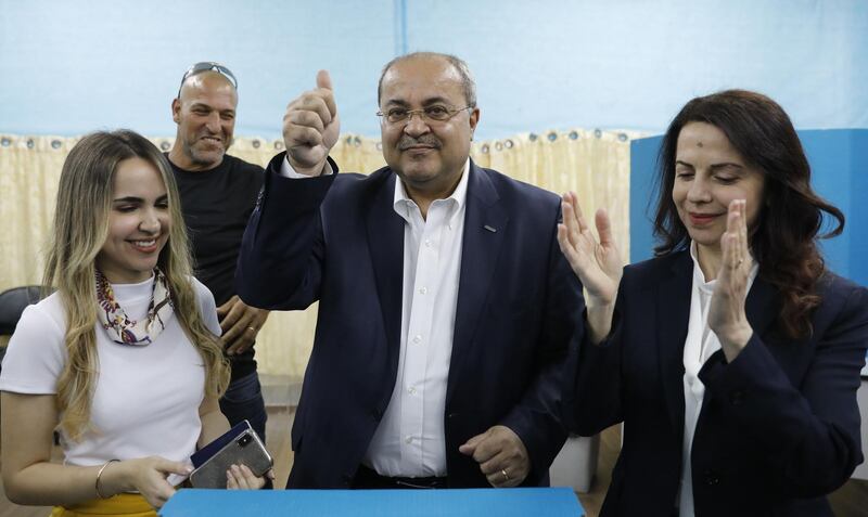 Israeli Arab politician Ahmed Tibi stands between his daughter (L) and wife as he casts his vote during Israel's parliamentary elections on April 9, 2019 in in the northern Israeli town of Taiyiba. Israelis voted today in a high-stakes election that will decide whether to extend Prime Minister Benjamin Netanyahu's long right-wing tenure despite corruption allegations or to replace him with an ex-military chief new to politics. / AFP / Ahmad GHARABLI
