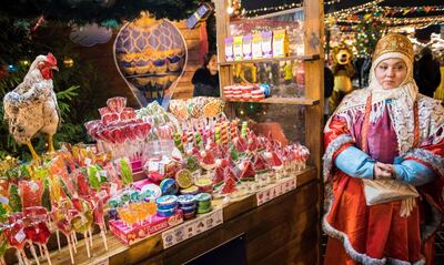 TOPSHOT - A vendor wearing a traditional dress sells sweets at a Christmas market in Red Square in Moscow on December 4, 2017. / AFP PHOTO / Mladen ANTONOV